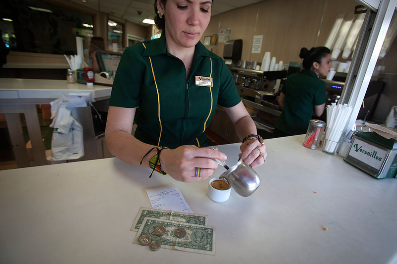 A server pours a cafecito in Miami’s famed Cafe Versailles